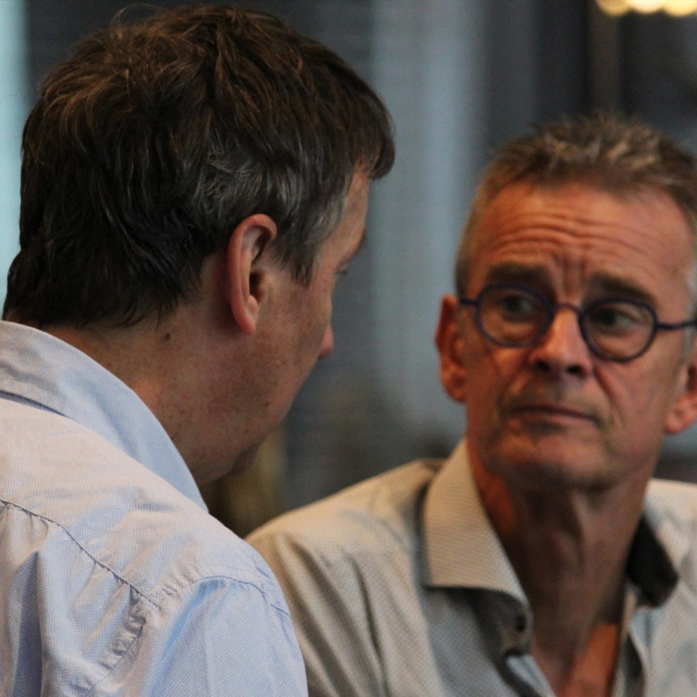 DISC-gedragsanalyse met een coach Mannelijke therapeut met bril voert DISC gesprek met mannelijke coachee