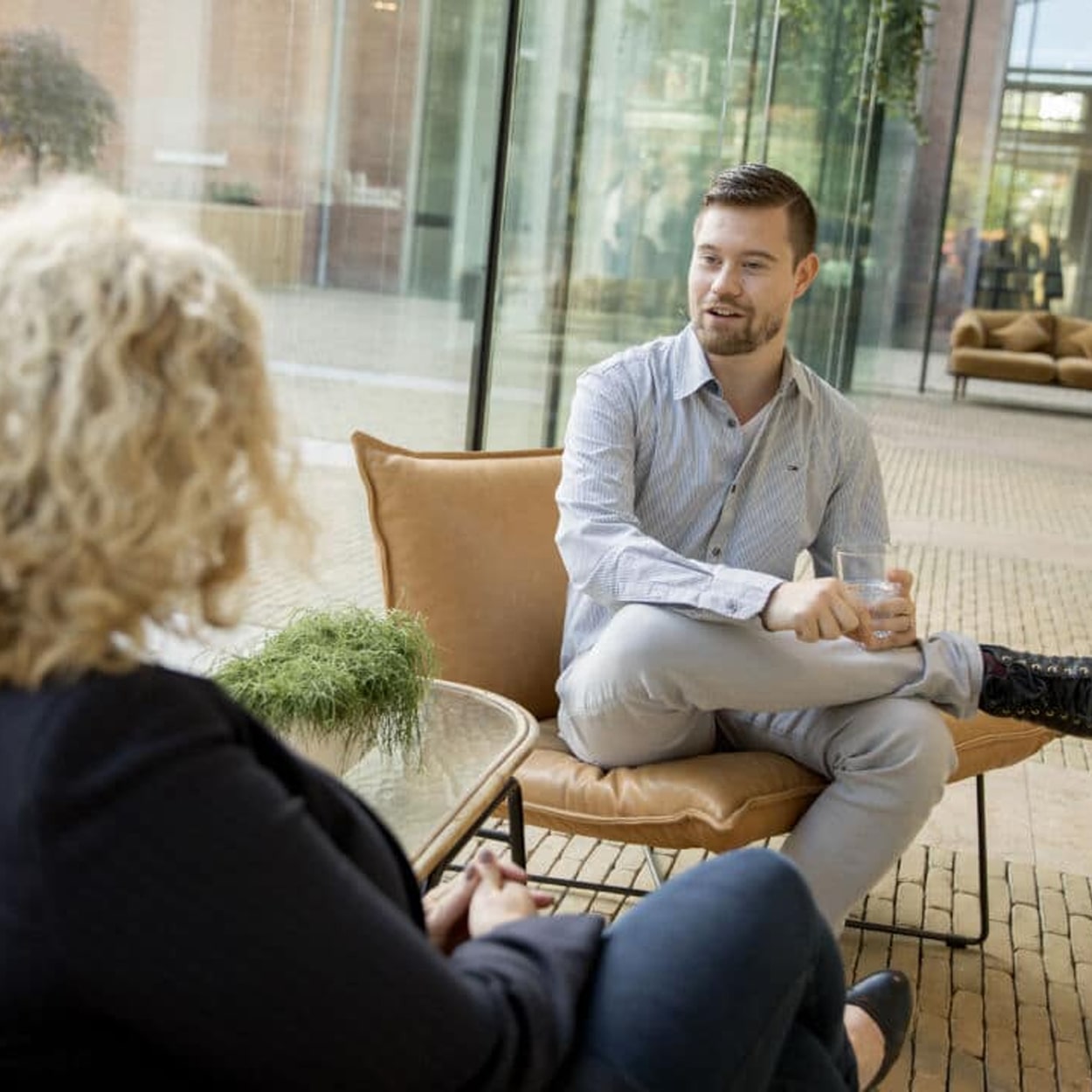 Jongeman in geanimeerd gesprek met een medewerker tijdens een consult met een bedrijfspsycholoog